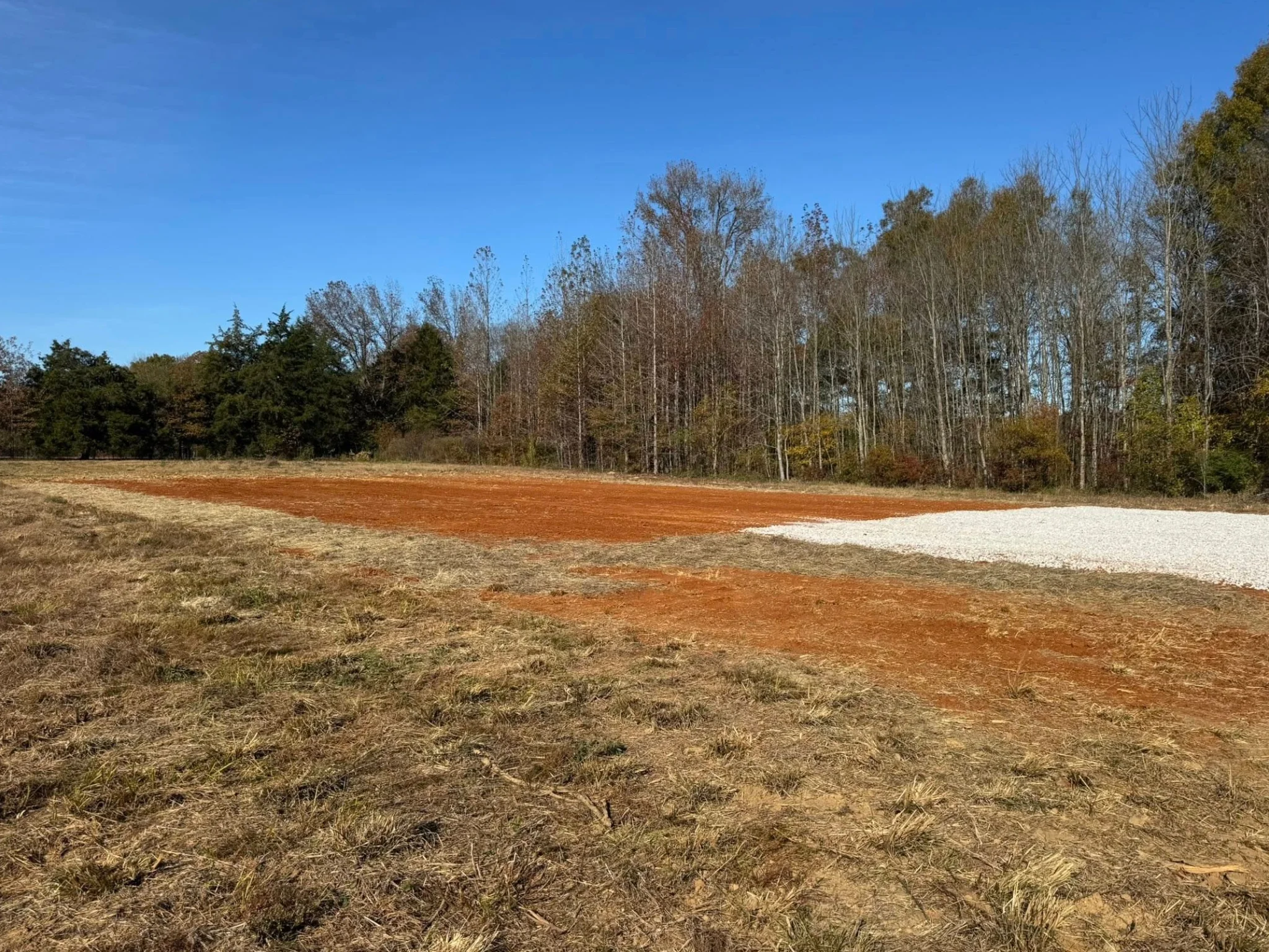 site preparation and dirt leveling for a new building pad with gravel base in mississippi.