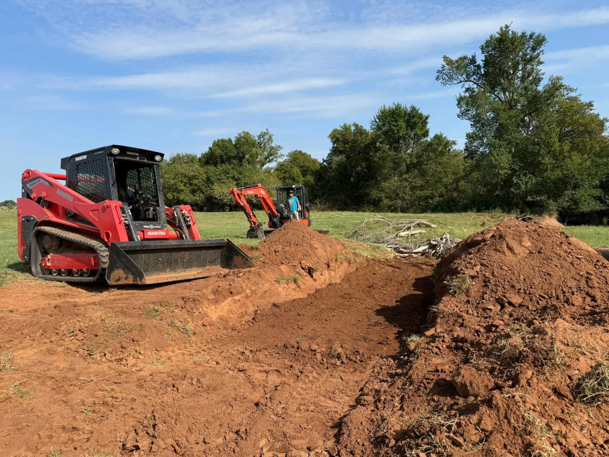 skid steer and excavator performing land clearing and excavation on a mississippi property.